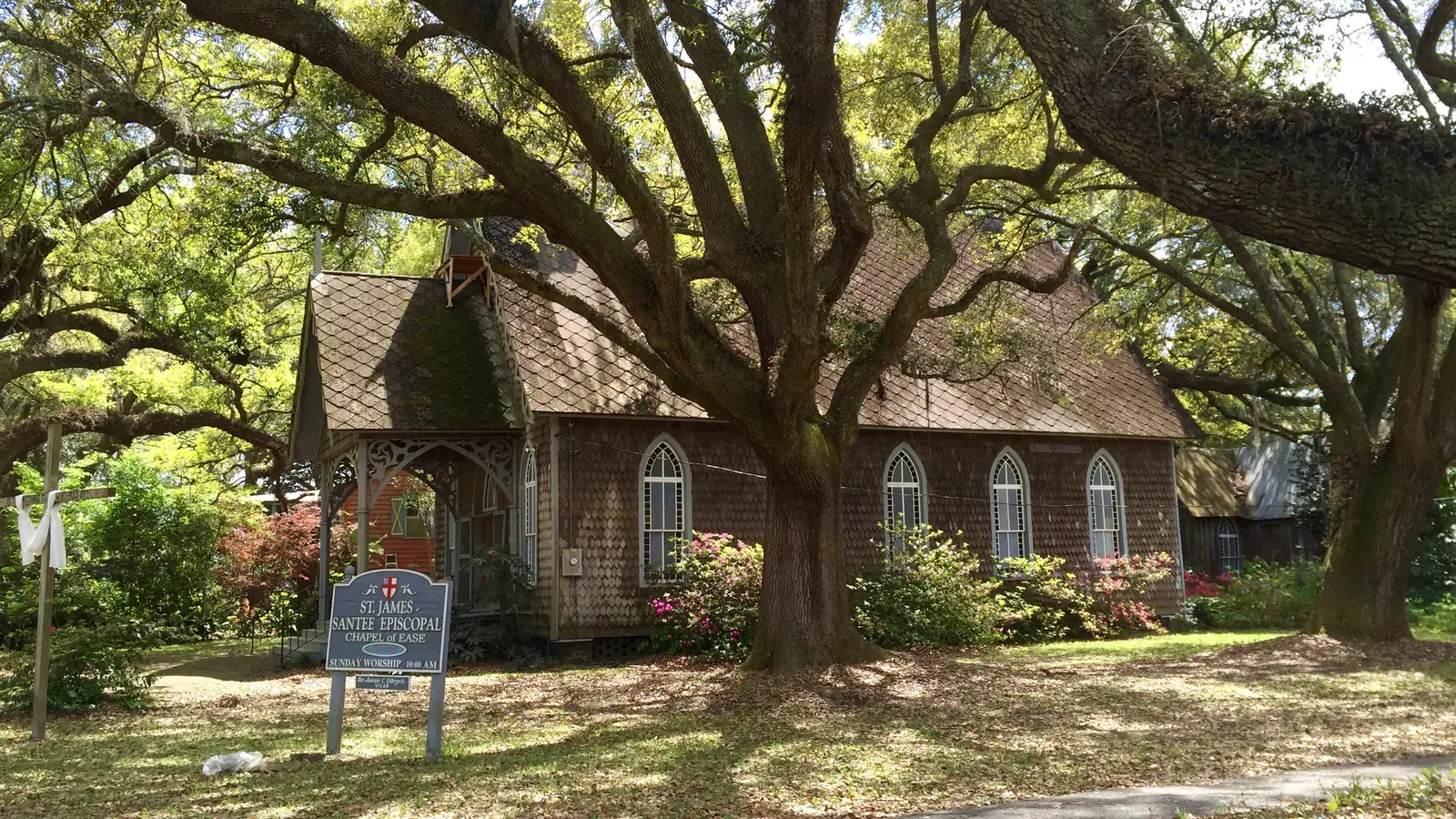 The small boarded-up wooden Old Bethel AME Church in McClellanville under live oaks – John B's secret place in The Cut.