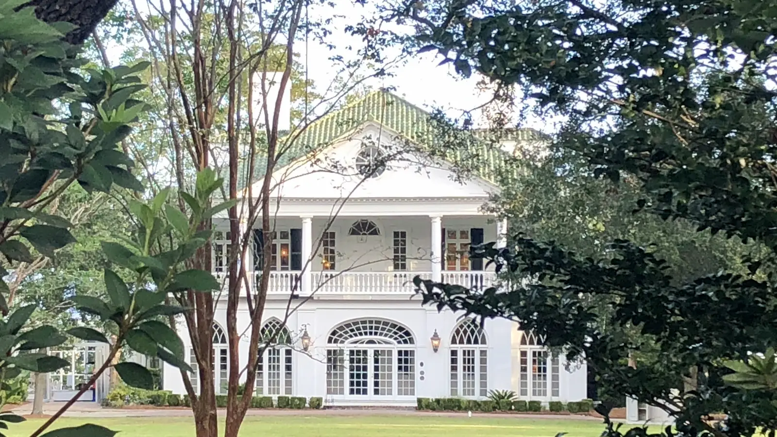The white 1786 house of Lowndes Grove with its columned porch above the lawn on the Ashley River – Tannyhill, the Cameron estate.